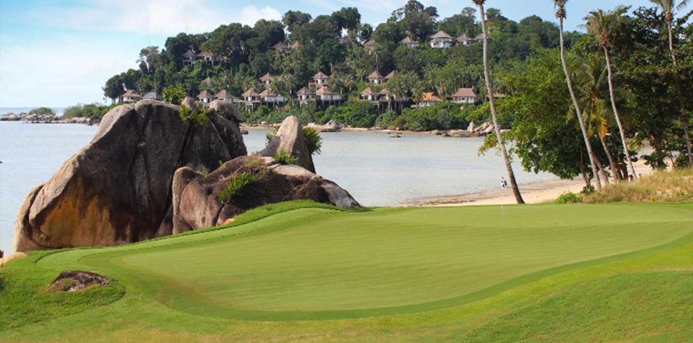 Golfers enjoying a round at Laguna Golf Bintan with scenic oceanfront fairways
