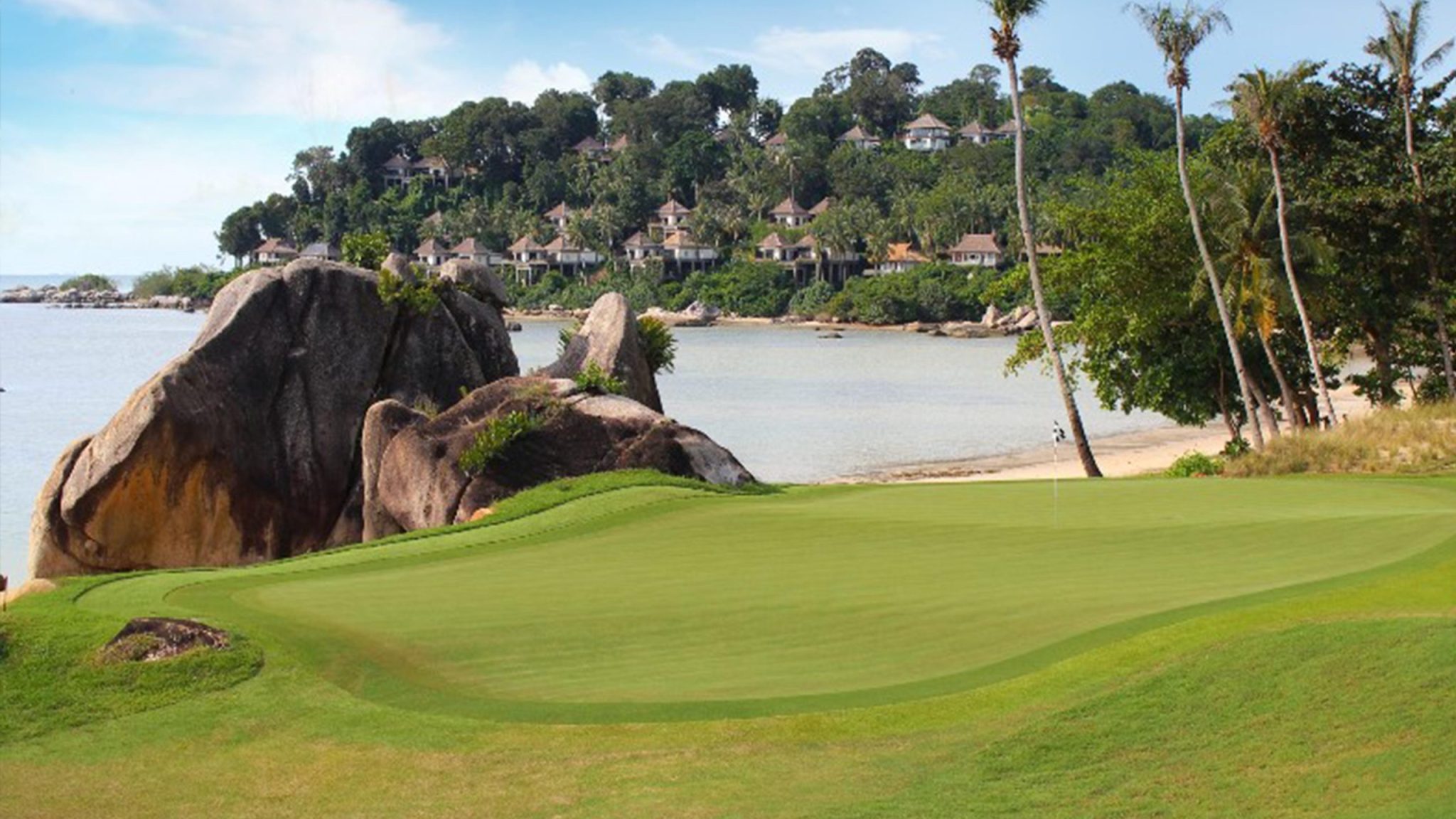 Golfers enjoying a round at Laguna Golf Bintan with scenic oceanfront fairways