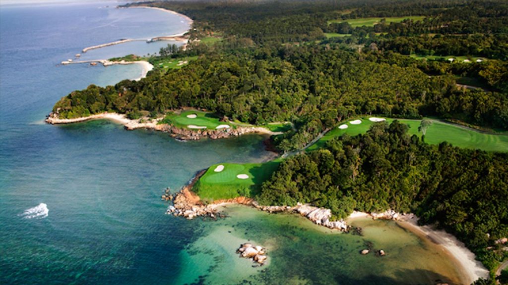 Professional golfer lining up a shot on the immaculate greens of Ria Bintan Golf Club