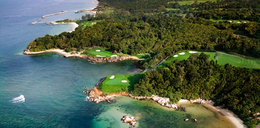 Professional golfer lining up a shot on the immaculate greens of Ria Bintan Golf Club