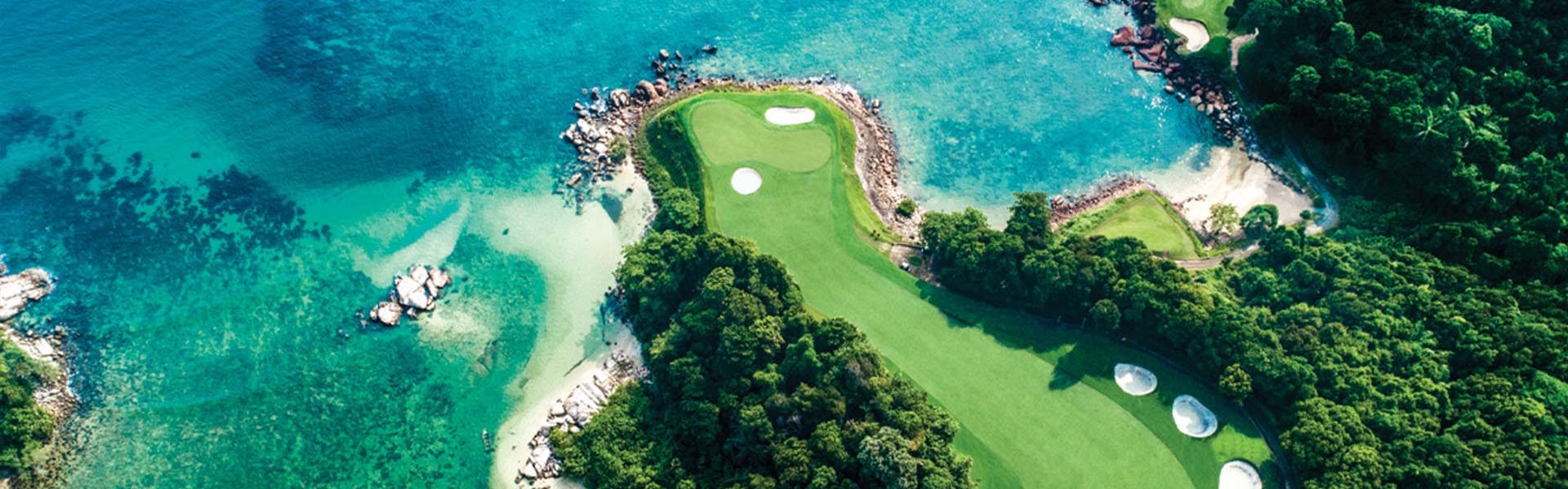 A golf cart on the scenic path surrounded by lush tropical greenery at Ria Bintan Golf Club