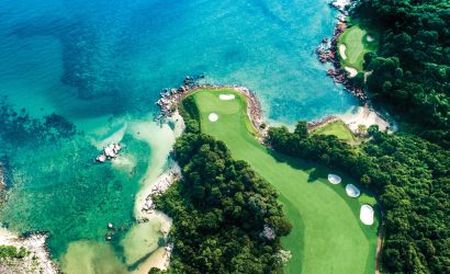 A golf cart on the scenic path surrounded by lush tropical greenery at Ria Bintan Golf Club