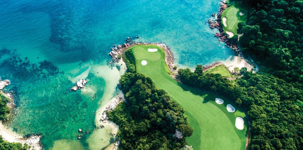 A golf cart on the scenic path surrounded by lush tropical greenery at Ria Bintan Golf Club