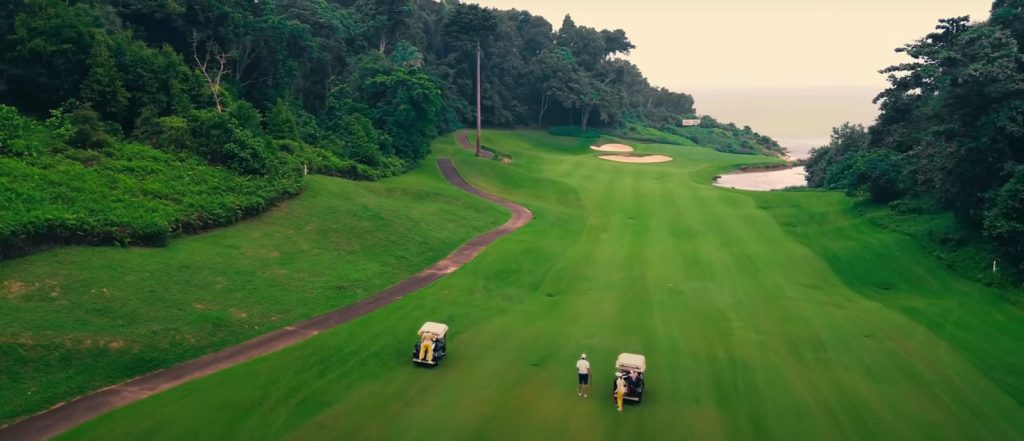 Golfer teeing off on the scenic cliffside hole at Ria Bintan Golf Club’s Ocean Course
